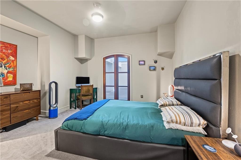 Bedroom with upholstered bed and arched door