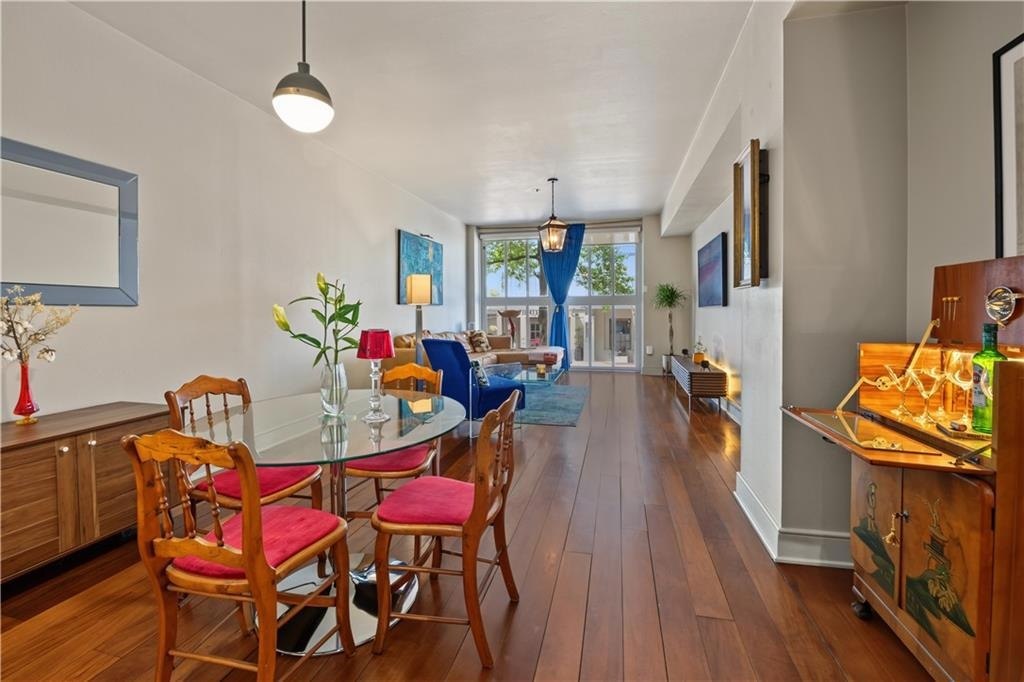 Dining and living areas connected by walnut flooring